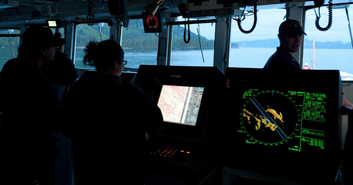 Ship bridge crew monitoring radar and navigation screens