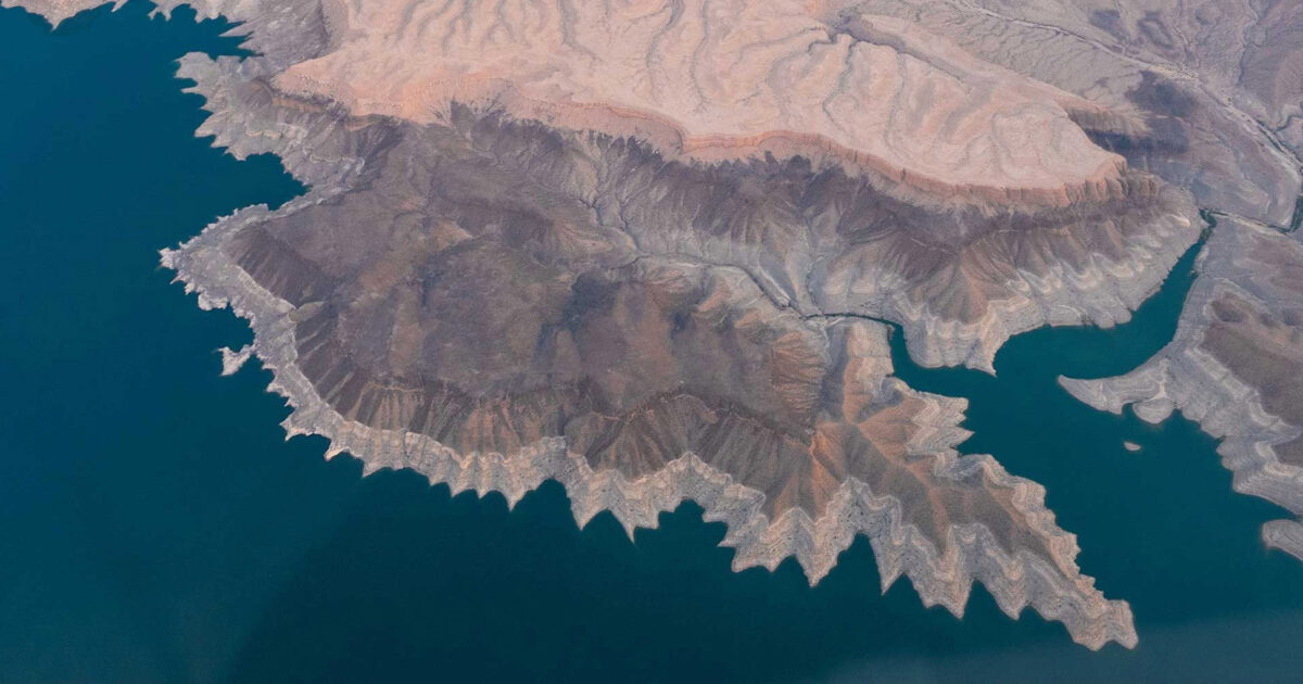 Aerial view of a desert canyon meeting a lake