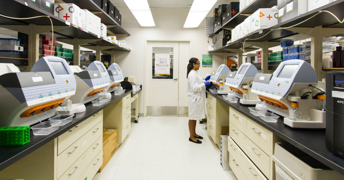 Lab technician working among genomic sequencing equipment
