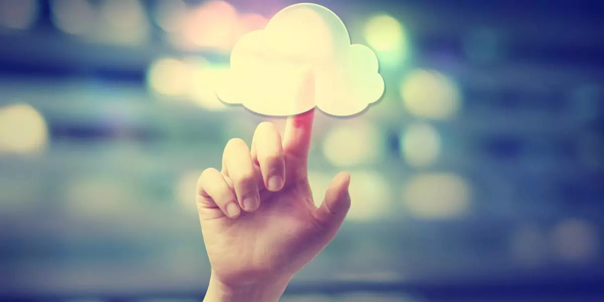 Hand touching a glowing white cloud icon against a blurred light background