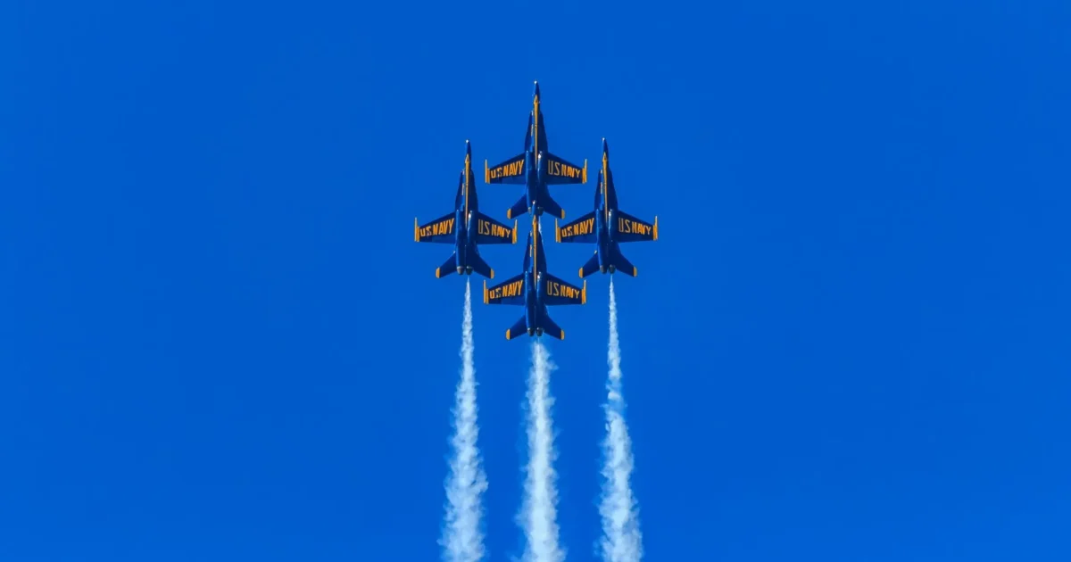 Navy Blue Angels jets flying in formation with contrails